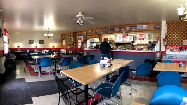 A diner with laminate tables and blue plastic chairs
