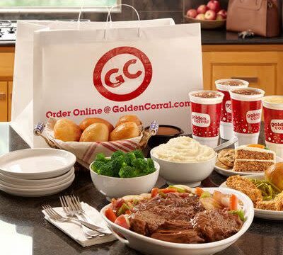White dishes of beef, broccoli, mashed potatoes, bread rolls, and a slice of carrot cake plus empty plates, cutlery and beverages displayed in front of a Golden Corral to-go bag