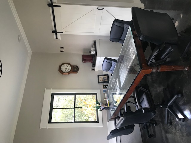 Five black office chairs around a wooden table